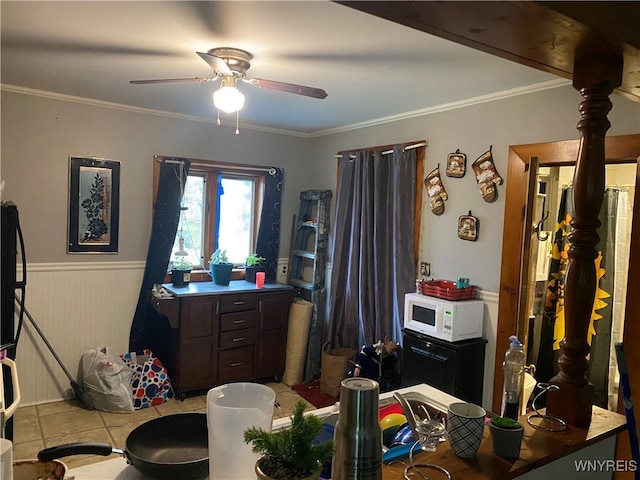 office area featuring light tile patterned flooring, ceiling fan, wooden walls, and ornamental molding