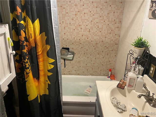 bathroom featuring tile walls, vanity, and shower / bath combo with shower curtain