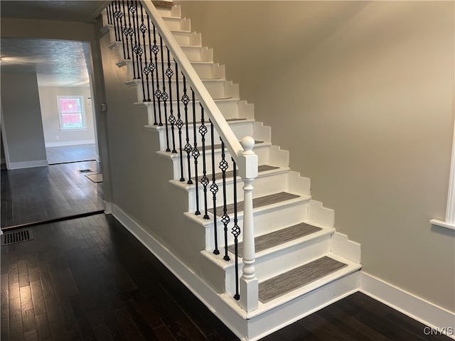 staircase with hardwood / wood-style flooring