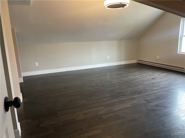 bonus room with dark hardwood / wood-style flooring, lofted ceiling, and a baseboard heating unit