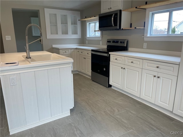 kitchen with white cabinetry, appliances with stainless steel finishes, sink, and a healthy amount of sunlight