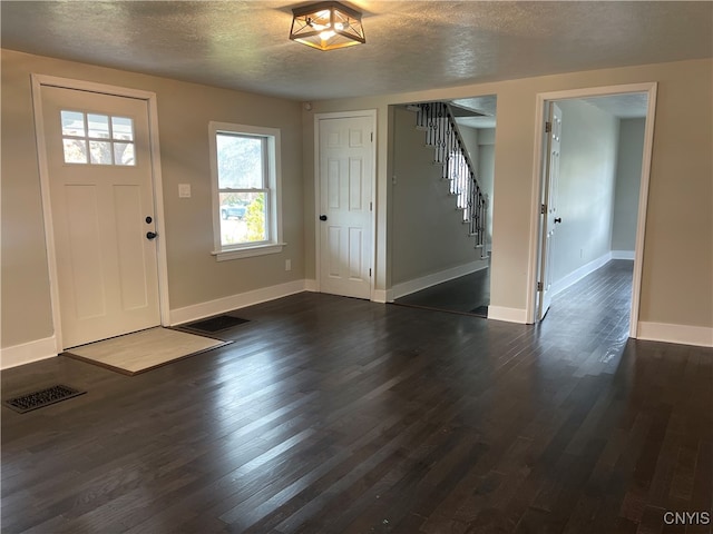 entrance foyer with dark wood-type flooring and a textured ceiling