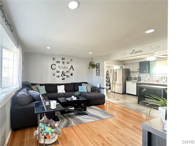 living room featuring hardwood / wood-style floors, ceiling fan, and sink