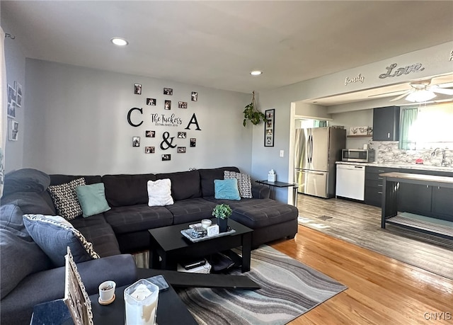 living room with ceiling fan and light hardwood / wood-style flooring