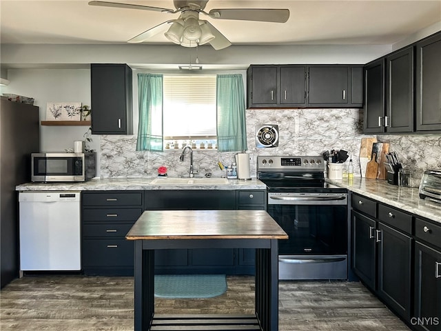 kitchen with backsplash, appliances with stainless steel finishes, sink, and dark hardwood / wood-style floors