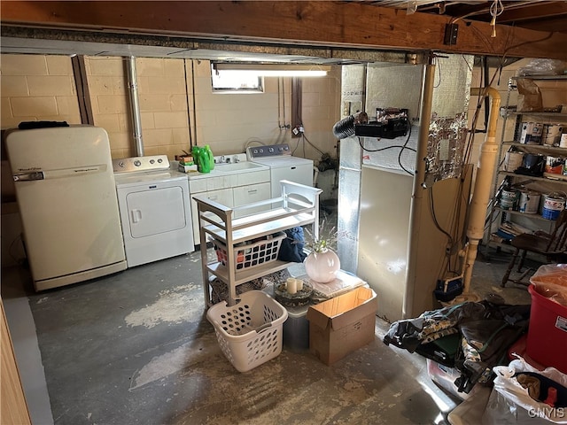 basement with separate washer and dryer and white fridge