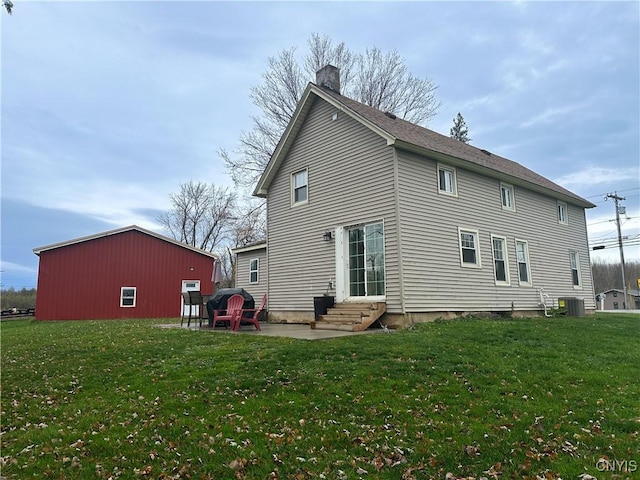 rear view of property with cooling unit, a yard, and a patio