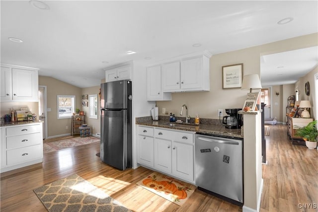 kitchen featuring white cabinetry, appliances with stainless steel finishes, sink, and dark stone countertops