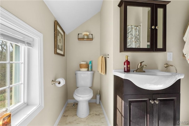 bathroom with vaulted ceiling, vanity, and toilet