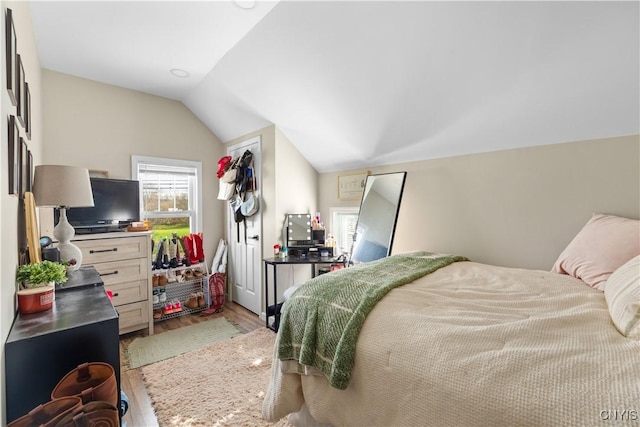 bedroom with hardwood / wood-style flooring and lofted ceiling