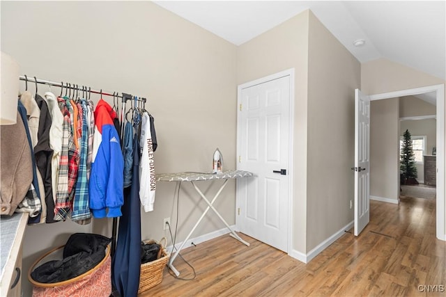 walk in closet featuring hardwood / wood-style flooring and vaulted ceiling