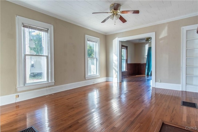 empty room with hardwood / wood-style flooring, plenty of natural light, crown molding, and ceiling fan