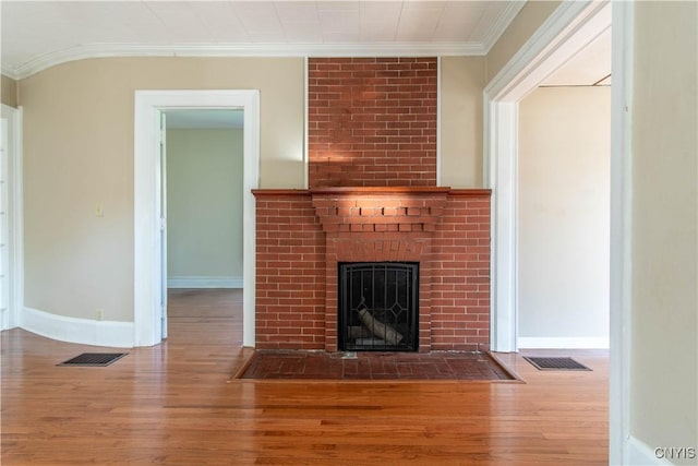 unfurnished living room with hardwood / wood-style flooring, a fireplace, and ornamental molding