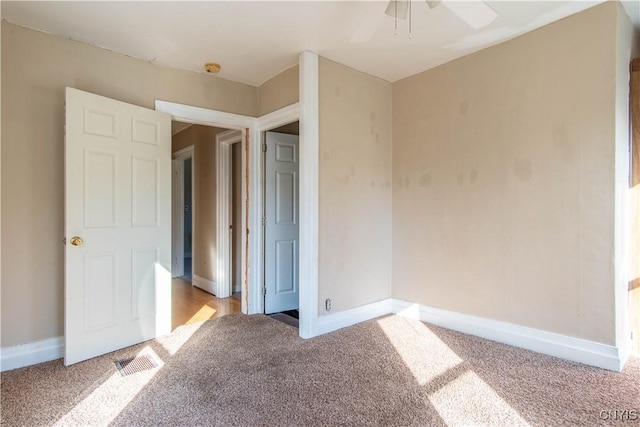 unfurnished bedroom with ceiling fan and light colored carpet