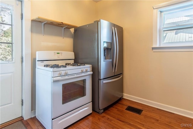 kitchen featuring stainless steel fridge with ice dispenser, gas range gas stove, and hardwood / wood-style floors