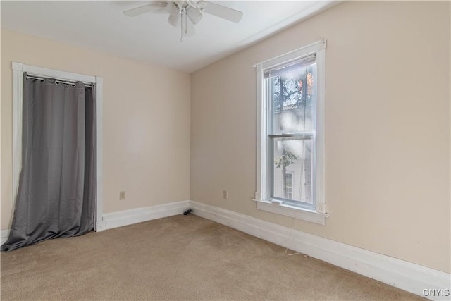 unfurnished room with light colored carpet and ceiling fan