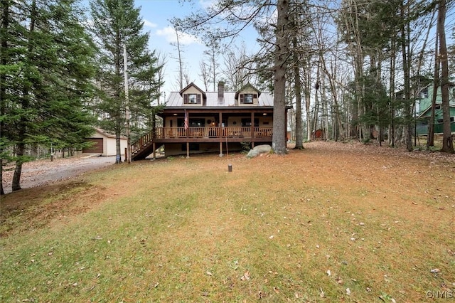 view of front facade with covered porch, a garage, an outdoor structure, and a front yard