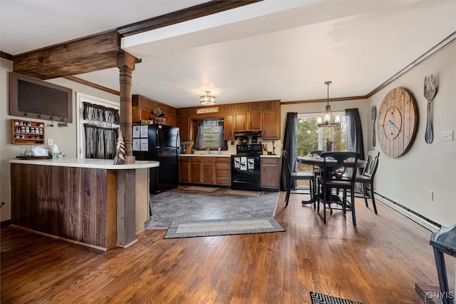 kitchen featuring dark hardwood / wood-style floors, a notable chandelier, kitchen peninsula, decorative light fixtures, and black appliances