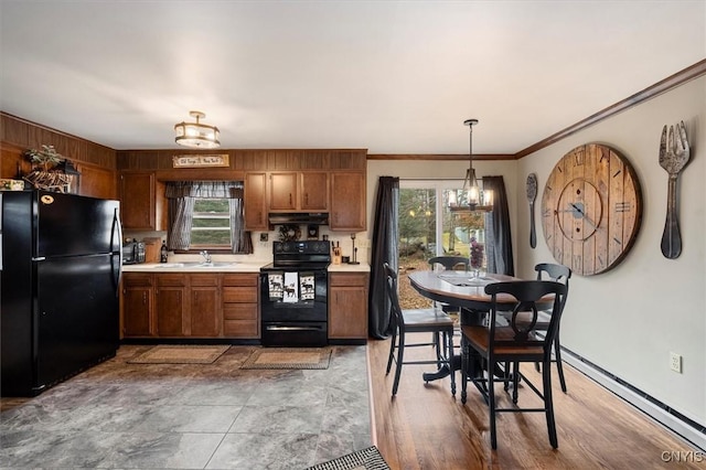 kitchen with sink, hanging light fixtures, an inviting chandelier, crown molding, and black appliances