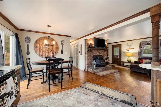 dining space with a wood stove, plenty of natural light, hardwood / wood-style floors, and ornamental molding