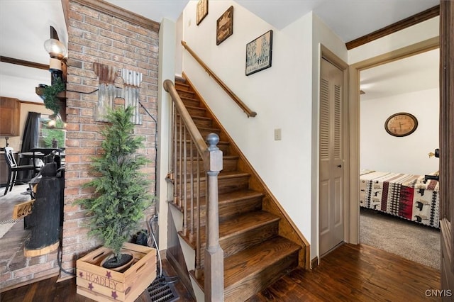 stairway featuring wood-type flooring and crown molding