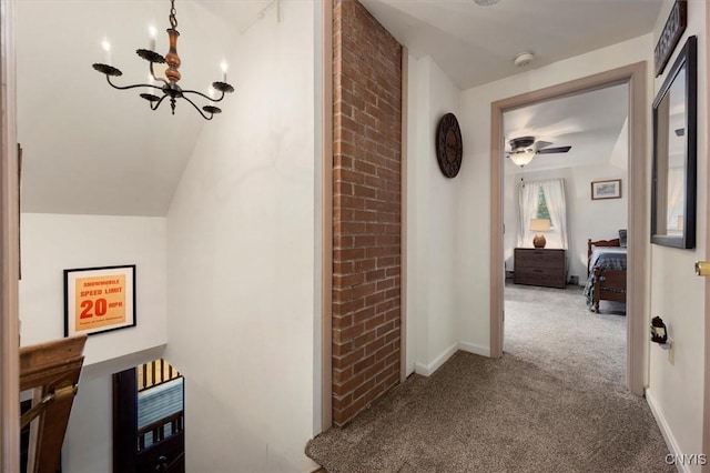 corridor featuring carpet, a chandelier, and lofted ceiling