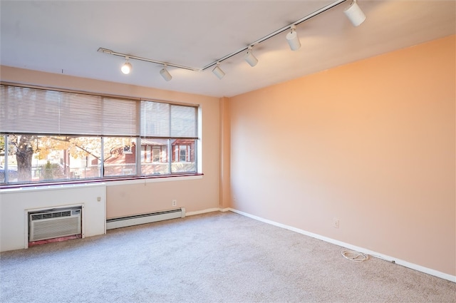 unfurnished room with baseboard heating, track lighting, carpet floors, and a wall mounted AC