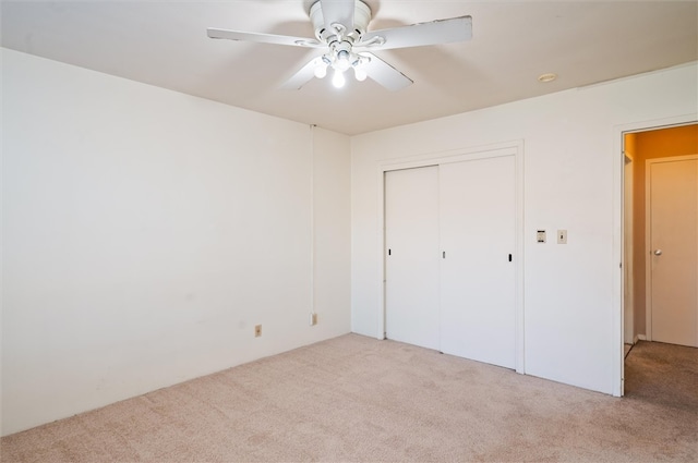 unfurnished bedroom featuring a closet, light carpet, and ceiling fan