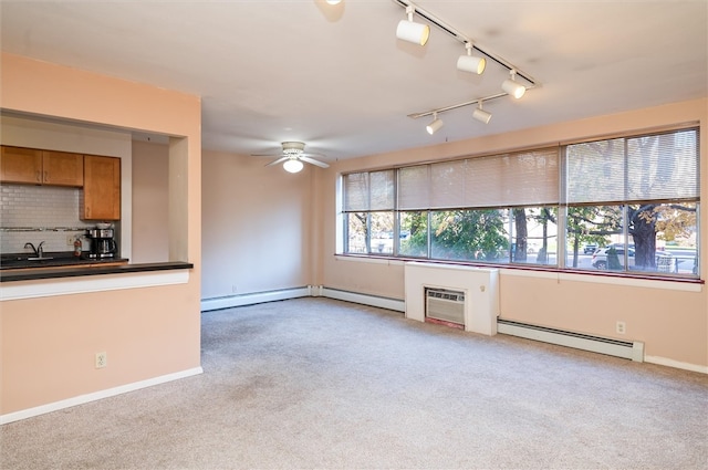 interior space featuring light carpet, baseboard heating, ceiling fan, and rail lighting