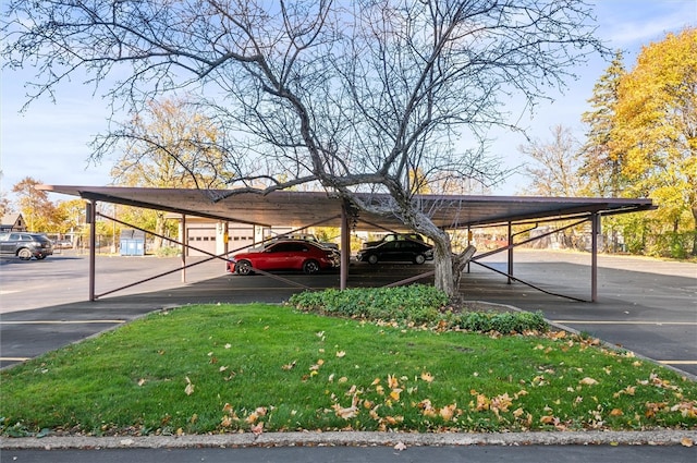 view of parking / parking lot with a yard and a carport