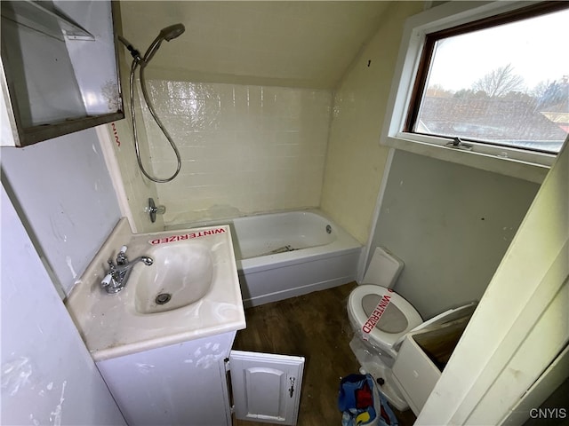 full bathroom with toilet, tiled shower / bath combo, vanity, and hardwood / wood-style floors