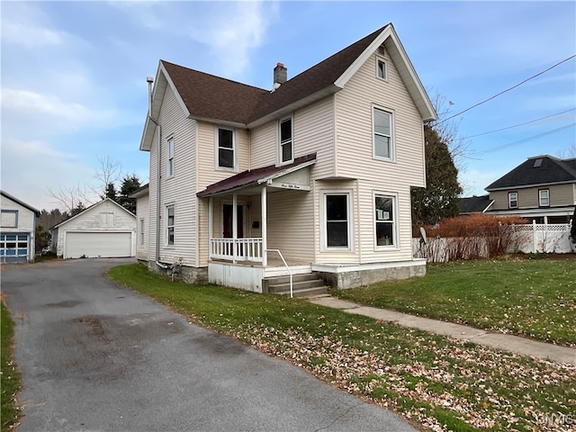 front facade featuring covered porch, a garage, an outdoor structure, and a front lawn