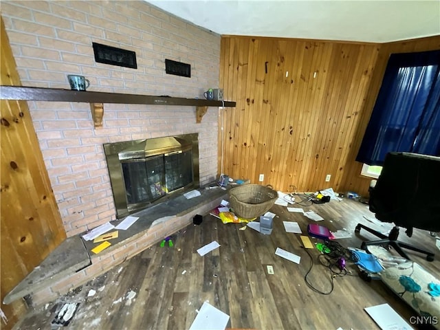 353 S James St, Wilna, NY 13619 - unfurnished living room featuring a brick fireplace, wood finished floors, and wood walls