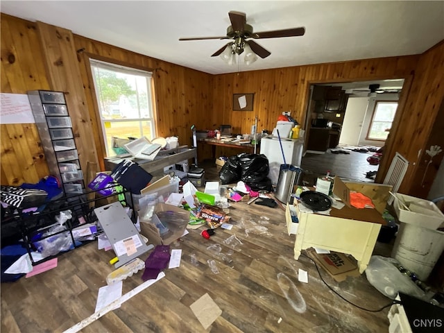 misc room with ceiling fan, wooden walls, and dark hardwood / wood-style flooring