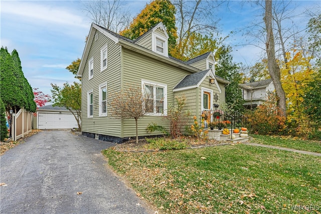 view of front of home featuring a front yard, a garage, and an outdoor structure