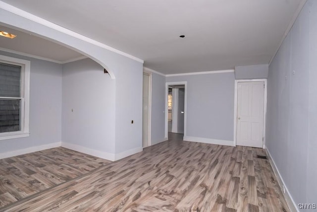 unfurnished room featuring crown molding and light wood-type flooring