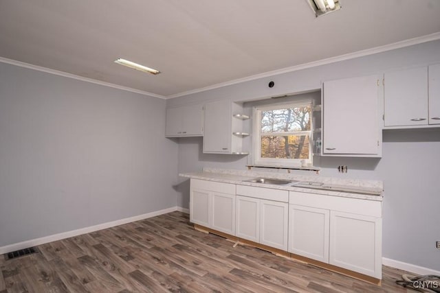 kitchen featuring dark hardwood / wood-style flooring, sink, ornamental molding, and white cabinets