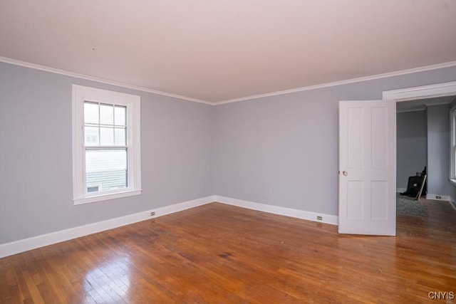 empty room with hardwood / wood-style flooring and ornamental molding