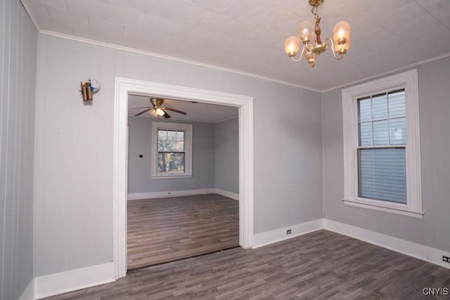 spare room featuring crown molding, dark wood-type flooring, and ceiling fan with notable chandelier