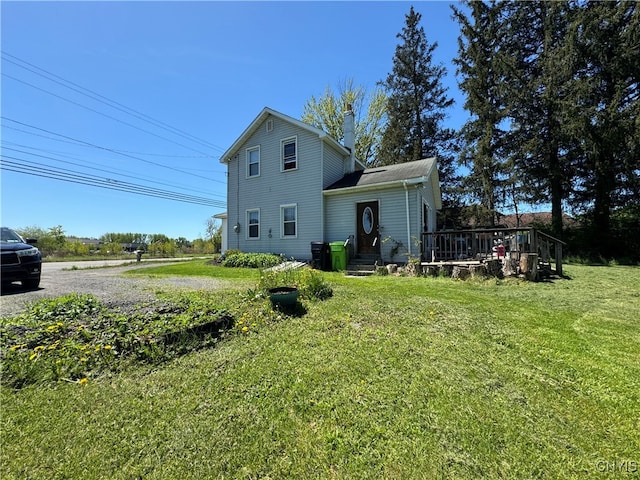 back of house featuring a wooden deck and a yard