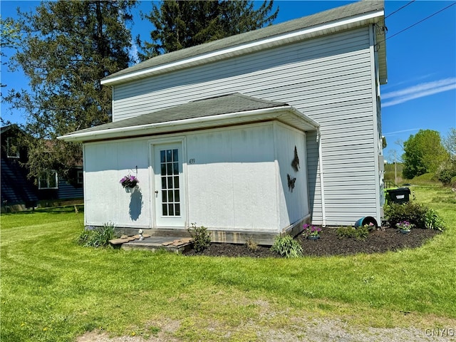 rear view of property featuring a lawn