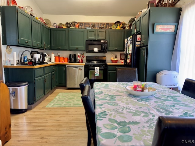 kitchen with green cabinetry, light hardwood / wood-style flooring, black appliances, and sink