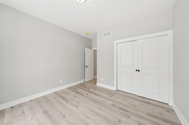 unfurnished bedroom featuring light hardwood / wood-style floors and a closet