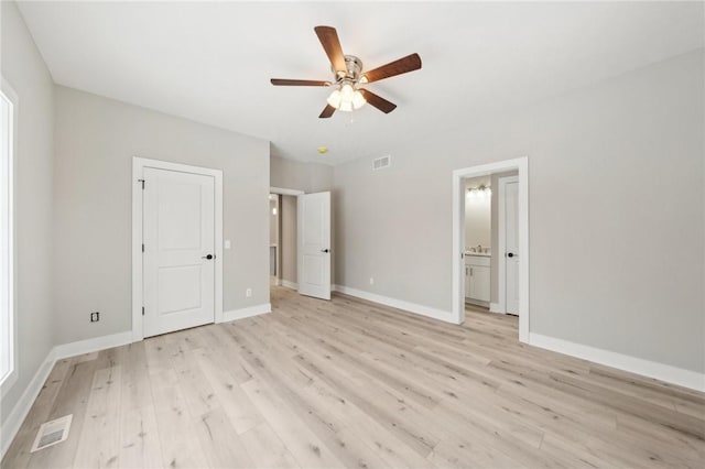 unfurnished bedroom featuring light wood-type flooring, ceiling fan, and connected bathroom