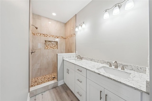 bathroom featuring vanity, tiled shower, and hardwood / wood-style floors