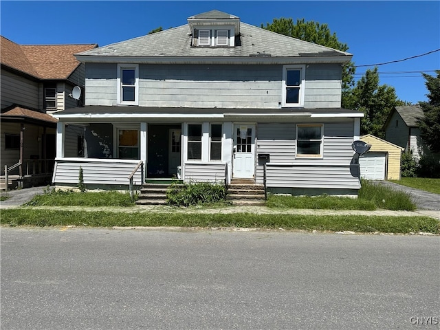 view of front of house featuring a garage, an outdoor structure, and a porch