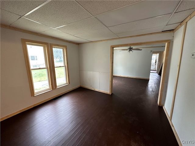 spare room with a paneled ceiling, dark hardwood / wood-style floors, and ceiling fan