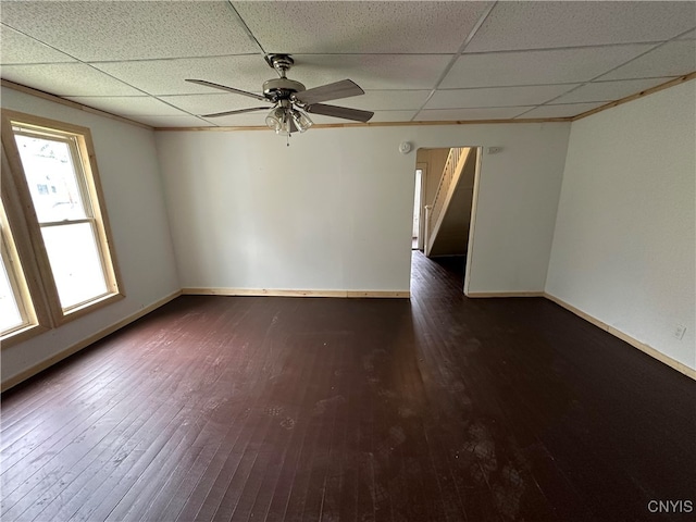 unfurnished room with a drop ceiling, dark wood-type flooring, and ceiling fan