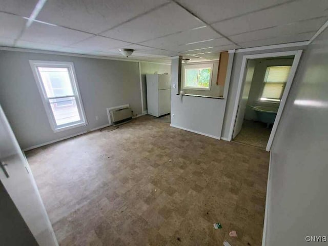 empty room with plenty of natural light and a paneled ceiling