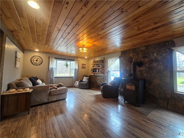 living room featuring dark wood-type flooring, wood ceiling, and a wood stove